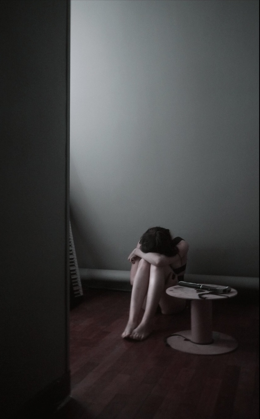Image d'une jeune femme, bras sur ses genoux